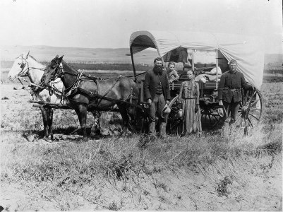 1600px-photograph_of_a_family_with_their_covered_wagon_during_the_great_western_migration2c_1866_-_nara_-_518267
